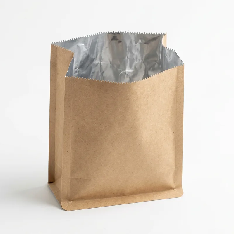 Brown kraft paper bag held open to show its aluminium foil inner lining and serrated top edge