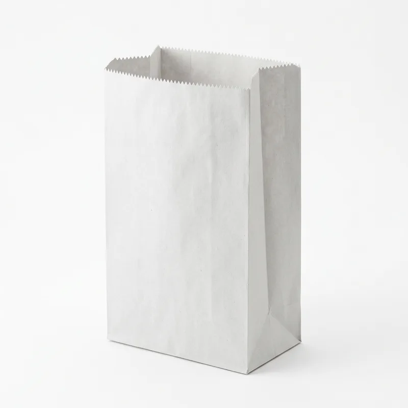 White kraft oil and grease resistant paper bag standing open on its square bottom, with a serrated top edge